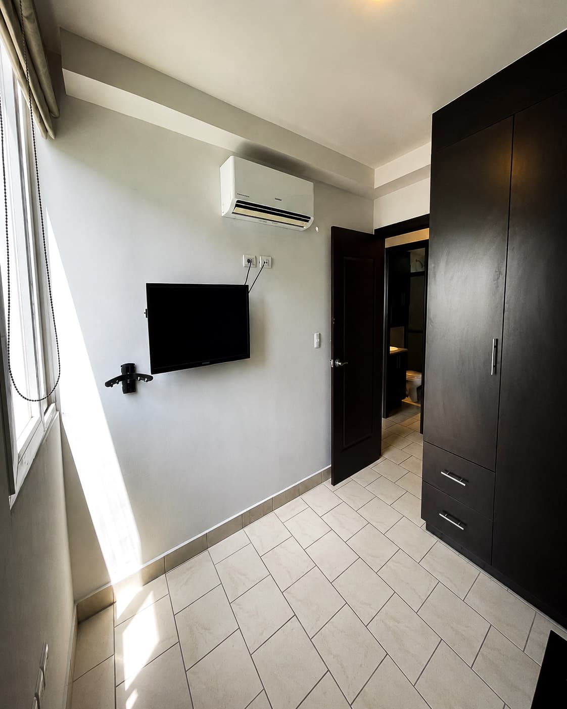 Habitación con clóset, aire acondicionado y baño en suite