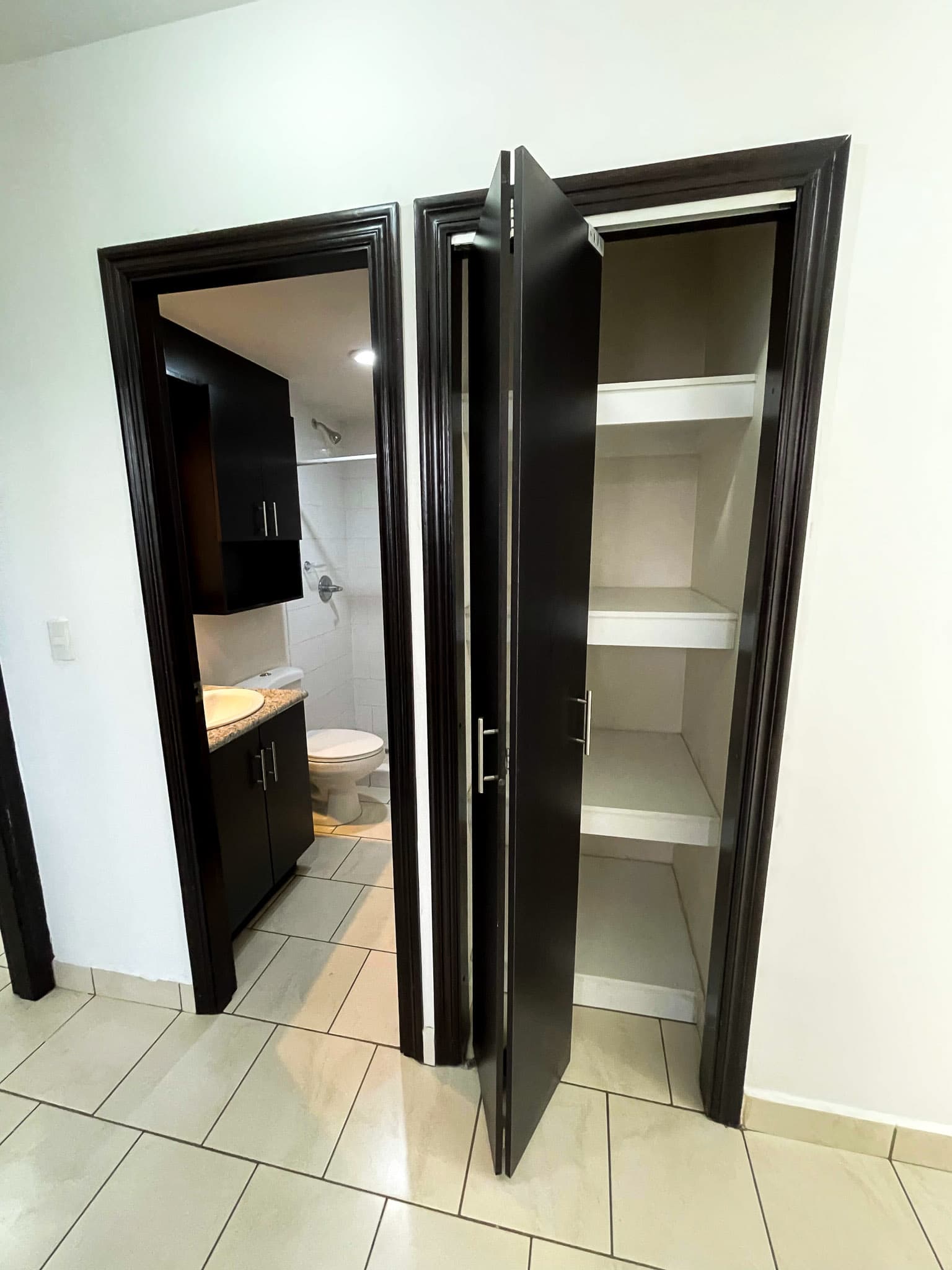 Pasillo con acceso al baño y clóset de blancos