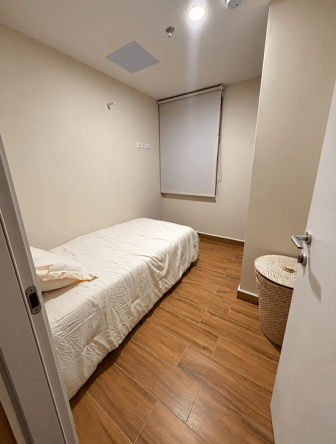 Habitación secundaria con cama y cortina roller