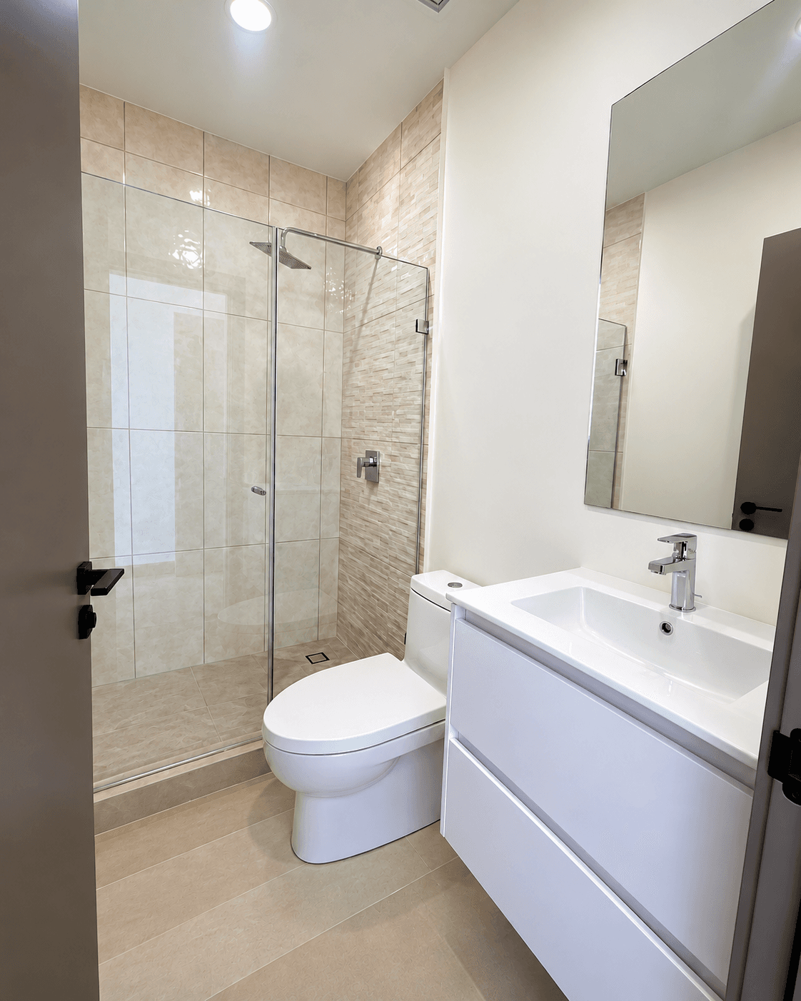 Baño completo con ducha de cristal, inodoro y lavamanos con espejo