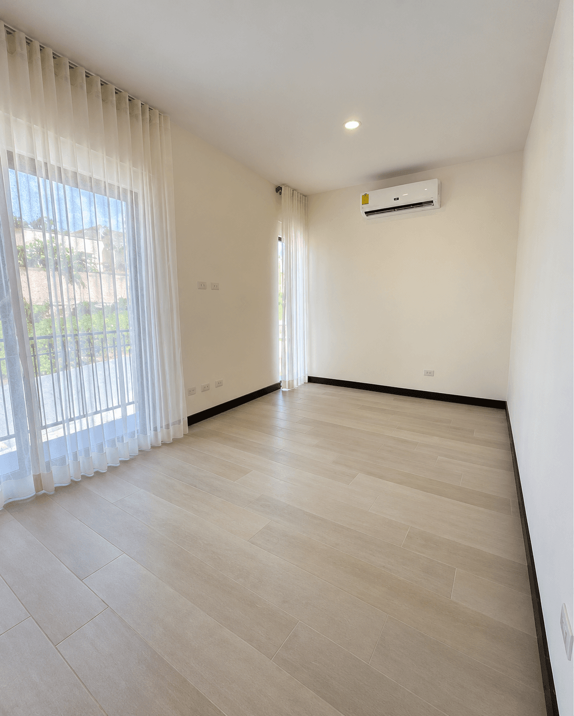 Habitación principal con aire acondicionado, cortinas y salida al balcón