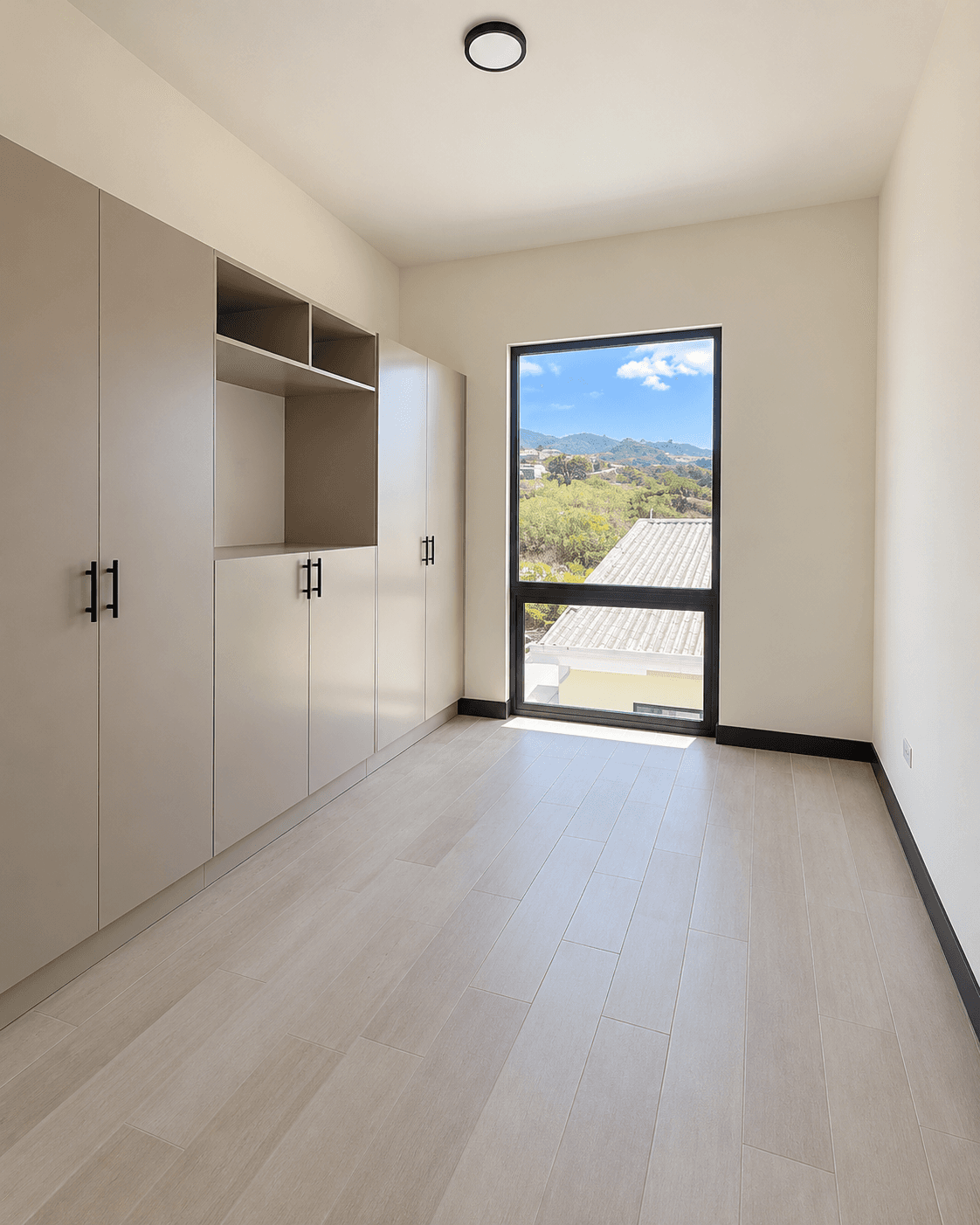 Habitación secundaria con clósets empotrados y ventana con vista a las montañas