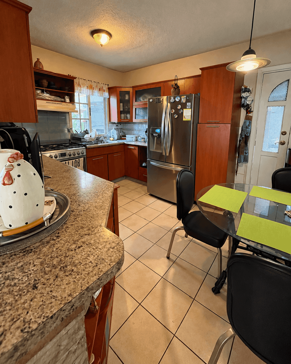 Cocina con refrigeradora, estufa y gabinetes de madera