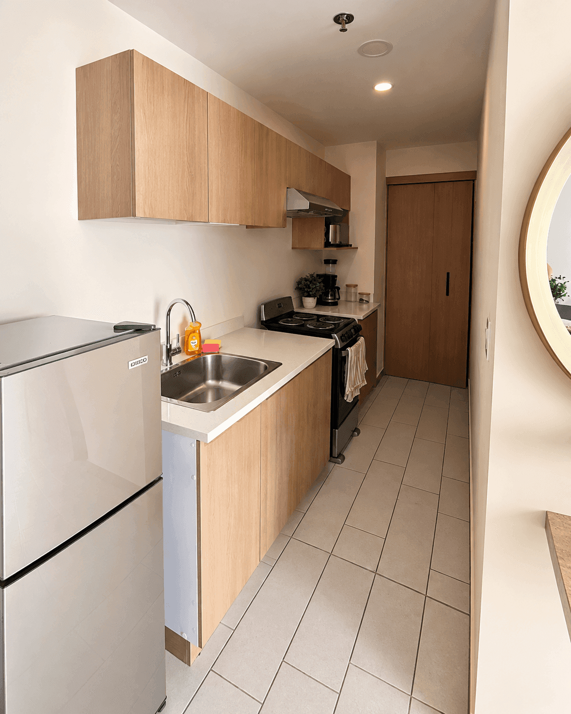 Cocina con gabinetes, extractor de humo y refrigeradora