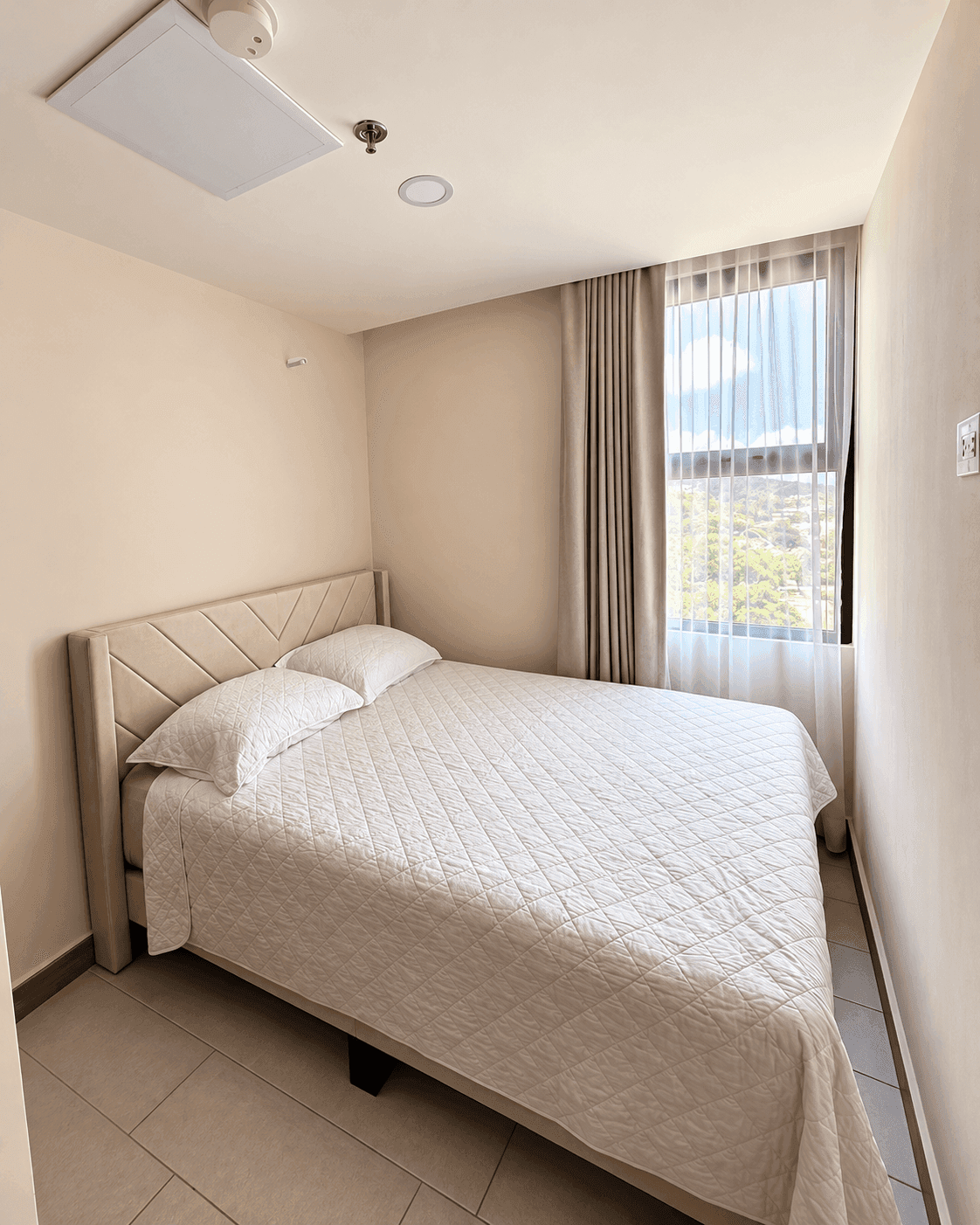 Habitación secundaria con cama, cortinas y ventana