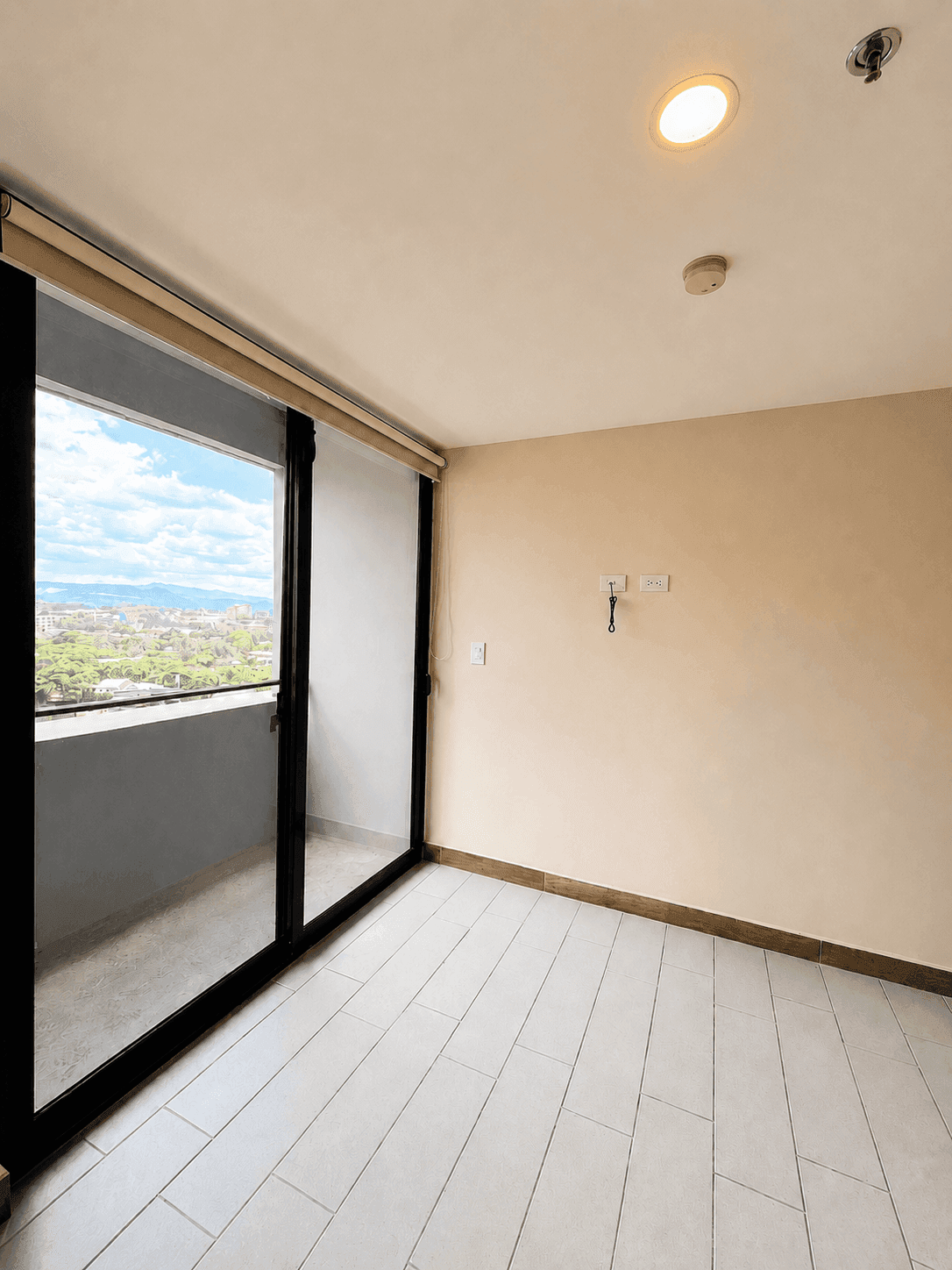 Habitación luminosa con salida a balcón y vista panorámica a la ciudad