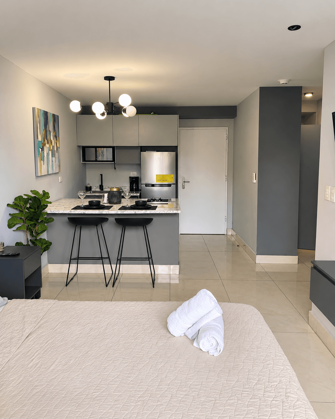 Ambiente principal con cama, cocina con barra y área de estar