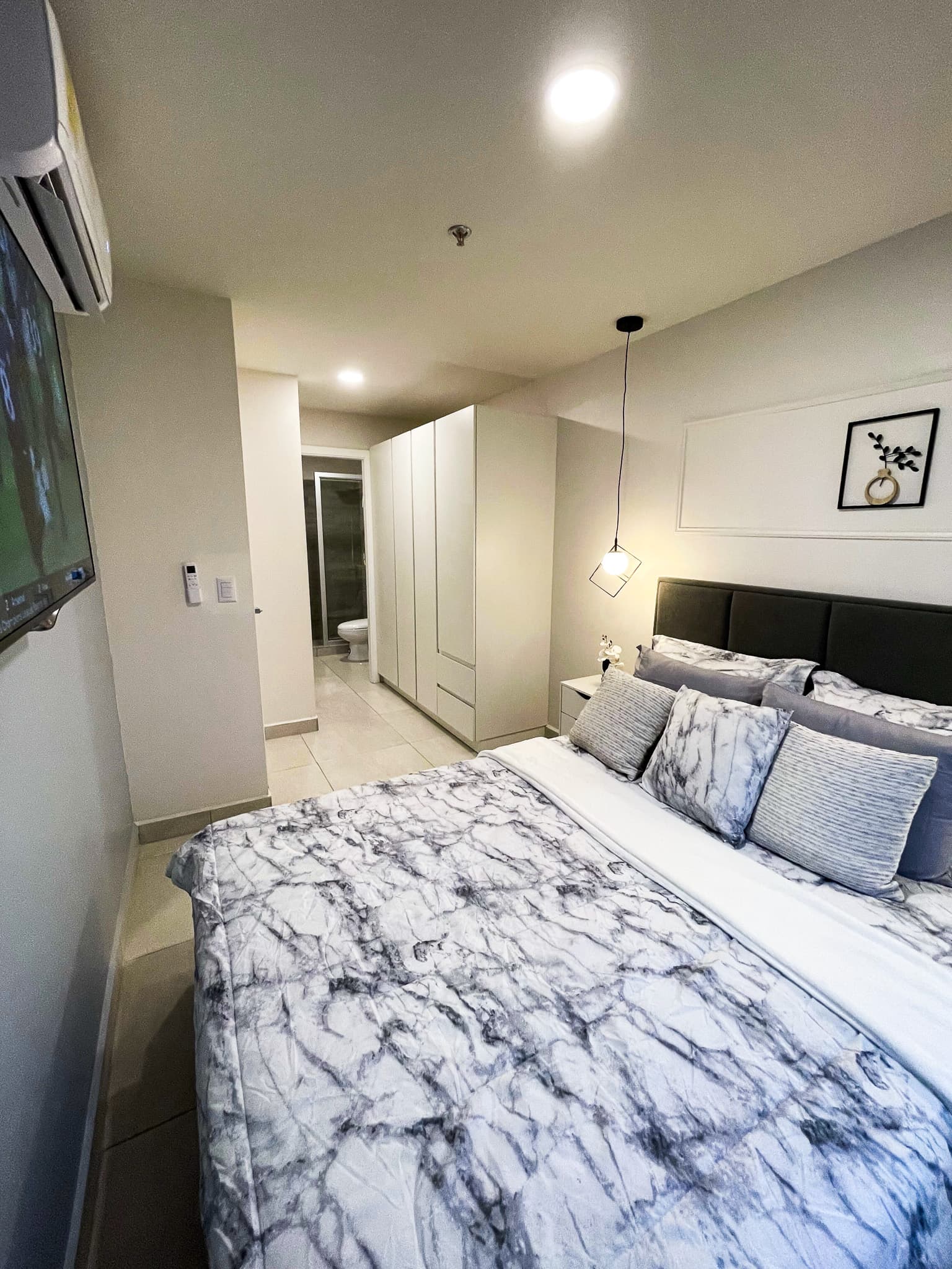Habitación con cama, mesa de noche y aire acondicionado