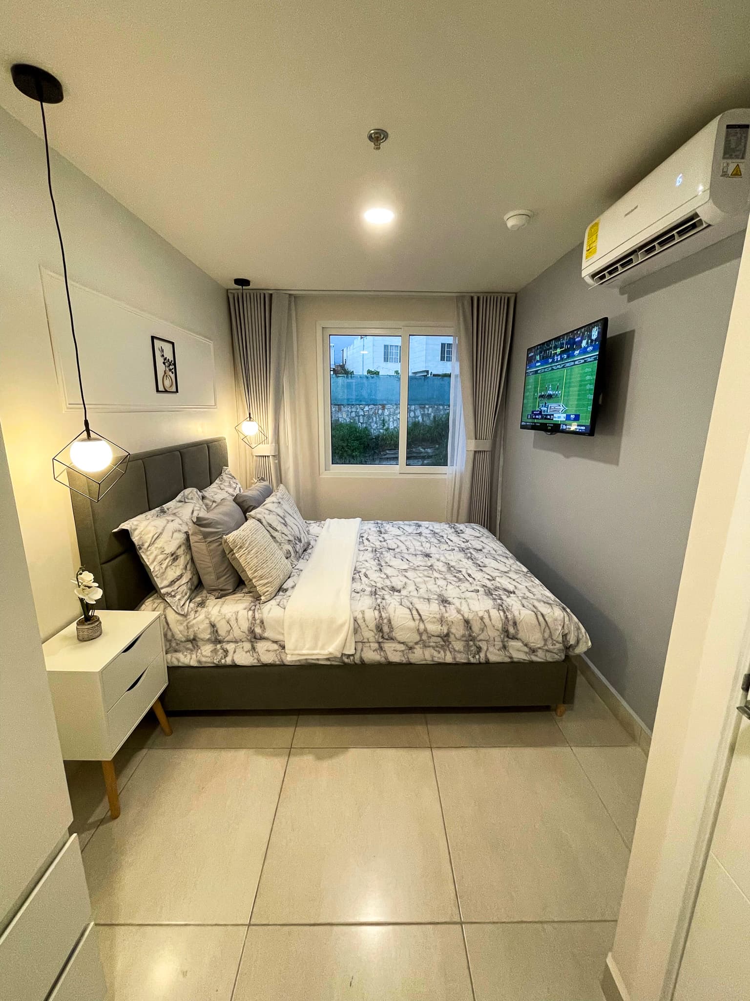Habitación con cama, ventana, aire acondicionado y TV
