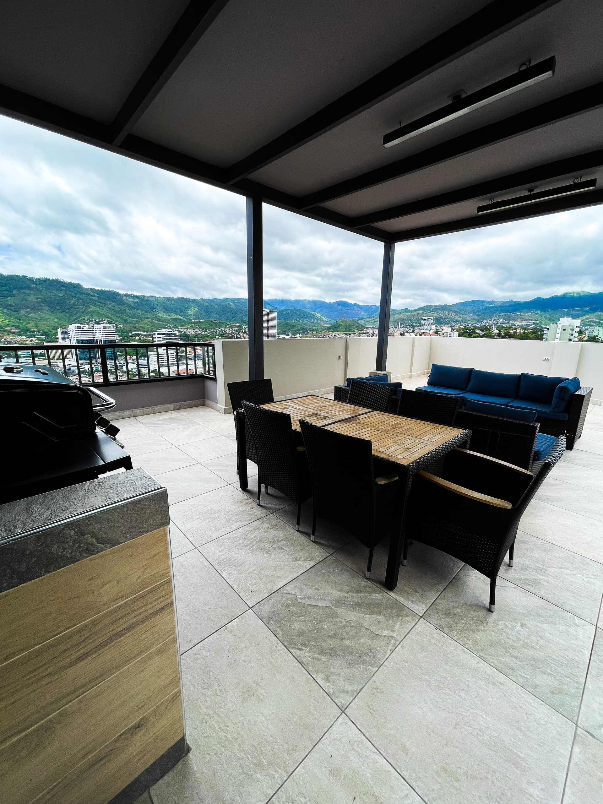 Área social con grill, comedor y vista panorámica a la ciudad